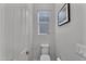 This powder room has neutral paint, a toilet and a small window letting in natural light at 20269 E Hummingbird Dr, Queen Creek, AZ 85142