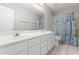 Bright bathroom featuring a double sink vanity, large mirror, toilet, and a shower with blue curtain at 21 E Irvine Rd, Phoenix, AZ 85086