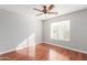 Bright bedroom featuring wood floors, a ceiling fan, and natural light from a window at 21 E Irvine Rd, Phoenix, AZ 85086
