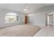 Bright living room with carpet, neutral paint, tiled entry, ceiling fan, and large windows at 21 E Irvine Rd, Phoenix, AZ 85086