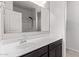 Modern bathroom vanity with a sink, mirror and dark cabinets, complemented by tile flooring and updated fixtures at 28512 N Geode Dr, San Tan Valley, AZ 85143