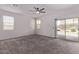 Carpeted bedroom with a ceiling fan, and sliding glass door leading to the outdoor patio at 28512 N Geode Dr, San Tan Valley, AZ 85143