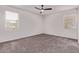 A bedroom with neutral walls, carpeted flooring, a ceiling fan, and two windows with blinds creates a calming space at 28512 N Geode Dr, San Tan Valley, AZ 85143