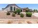 Well-maintained front yard with desert landscaping, shrubs, and flowers is easy care and appealing at 28512 N Geode Dr, San Tan Valley, AZ 85143