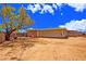 Spacious backyard with a large tree, dirt ground, and block wall, offering privacy and potential at 3450 W Kaler Dr, Phoenix, AZ 85051