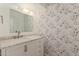 Elegant bathroom featuring a vanity with marble countertop and a beautiful mirror and botanical wallpaper at 3450 W Kaler Dr, Phoenix, AZ 85051