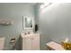 Powder room featuring blue walls, white vanity, mirror and traditional fixtures at 3450 W Kaler Dr, Phoenix, AZ 85051