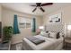 Comfortable bedroom with plush headboard, soft bedding, ceiling fan, and window with curtains at 3450 W Kaler Dr, Phoenix, AZ 85051