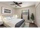 Inviting bedroom with neutral colors, ceiling fan, large window, and stylish artwork at 3450 W Kaler Dr, Phoenix, AZ 85051