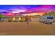 Charming single-story home featuring a brick exterior, desert landscaping, and a two-car garage during a lovely sunset at 3450 W Kaler Dr, Phoenix, AZ 85051