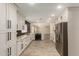 Bright kitchen with white cabinetry, sleek countertops, and stainless steel appliances, open to living area at 3450 W Kaler Dr, Phoenix, AZ 85051