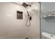 Modern shower with white tile, a black shower head and a storage cutout at 3450 W Kaler Dr, Phoenix, AZ 85051