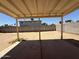 Backyard view of a covered patio and dirt yard with block wall at 3827 E Sweetwater Ave, Phoenix, AZ 85032