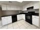 Kitchen features white cabinetry, black countertops, and tiled flooring at 3827 E Sweetwater Ave, Phoenix, AZ 85032