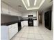 Well-lit kitchen with white cabinets, black countertops, and modern appliances at 3827 E Sweetwater Ave, Phoenix, AZ 85032