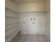 Large laundry room with ample shelving and tile flooring at 3827 E Sweetwater Ave, Phoenix, AZ 85032