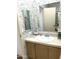 Bathroom featuring wood cabinets, a sink, and a decorative mirror and wallpaper at 501 E Ray Rd # 230, Chandler, AZ 85225