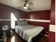 Cozy bedroom featuring red walls, a comfortable queen-sized bed, and a modern ceiling fan at 501 E Ray Rd # 230, Chandler, AZ 85225