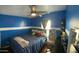 Bright bedroom featuring blue walls, a comfortable queen-sized bed, and a modern ceiling fan at 501 E Ray Rd # 230, Chandler, AZ 85225