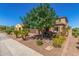Beautiful home featuring desert landscaping, a lush green tree and stone accents at 5235 S Dante --, Mesa, AZ 85212
