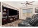 Cozy living room featuring a large flat-screen TV, custom shelving, and plush reclining seating at 5235 S Dante --, Mesa, AZ 85212