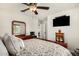 This main bedroom has a ceiling fan, a TV, and a large bed with a tan and white floral comforter at 5235 S Dante --, Mesa, AZ 85212
