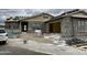 Exterior view of a home under construction featuring a gray exterior, open garage and tile roof at 6446 E Omega Cir, Mesa, AZ 85215