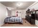 Cozy bedroom featuring a plaid bedspread and an entertainment center against a white wall at 705 S Pima --, Mesa, AZ 85210