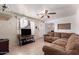Inviting living room features a comfortable sectional sofa, tiled floors, and a ceiling fan for added comfort at 705 S Pima --, Mesa, AZ 85210