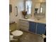 Bathroom features a yellow toilet, blue vanity cabinets, white walls, and a window for natural light at 7807 E Main St # H-20, Mesa, AZ 85207