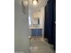 Hall view of bathroom featuring blue cabinets, neutral tile flooring, and ample lighting at 7807 E Main St # H-20, Mesa, AZ 85207