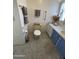 Bathroom featuring a yellow toilet, white walls, gray tile flooring, and towel rack at 7807 E Main St # H-20, Mesa, AZ 85207