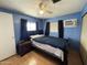 Blue bedroom with bed, ceiling fan, window, and air conditioning unit at 7807 E Main St # H-20, Mesa, AZ 85207