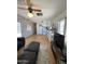 Inviting living room and kitchen area with laminate floors, ceiling fan, and comfortable leather seating at 7807 E Main St # H-20, Mesa, AZ 85207