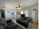 Inviting living room and kitchen area with laminate floors, ceiling fan, and comfortable leather seating at 7807 E Main St # H-20, Mesa, AZ 85207