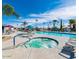Outdoor pool area with hot tub, chairs, umbrellas and palm trees under a blue sky at 7807 E Main St # H-20, Mesa, AZ 85207