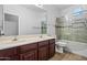 Bright bathroom featuring a double sink vanity and shower over tub with glass sliding doors at 7911 E Posada Ave, Mesa, AZ 85212