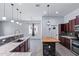 Open-concept kitchen with stainless steel appliances, a butcher block island and an eat-in breakfast bar with granite countertops at 7911 E Posada Ave, Mesa, AZ 85212