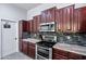 This renovated kitchen offers wood cabinets, a stainless steel oven and microwave and granite countertops at 7911 E Posada Ave, Mesa, AZ 85212