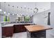 A modern kitchen showcasing a butcher block island with seating, granite countertops, and stainless steel appliances at 7911 E Posada Ave, Mesa, AZ 85212