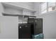 Contemporary laundry room with black washer and dryer with shelving above at 7911 E Posada Ave, Mesa, AZ 85212