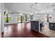 Open-concept living room features wood floors, abundant natural light and a stylish kitchen island at 7911 E Posada Ave, Mesa, AZ 85212