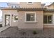 Beige home featuring rock landscaping, traditional windows, and a covered entryway at 8468 W Lewis Ave, Phoenix, AZ 85037