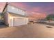 Spacious two-car garage and driveway provides ample parking, set against a colorful sky at 8468 W Lewis Ave, Phoenix, AZ 85037