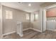 Hallway featuring wood floors, two windows, and a laundry room at 8468 W Lewis Ave, Phoenix, AZ 85037