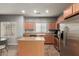 Well-lit kitchen with stainless steel appliances, center island, and ample cabinet space at 8468 W Lewis Ave, Phoenix, AZ 85037