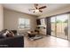 Cozy living room with tile flooring, ceiling fan, mounted TV, and sliding door to the patio at 8468 W Lewis Ave, Phoenix, AZ 85037