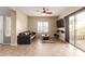 Comfortable living room featuring tile flooring, neutral walls, ceiling fan, and sliding door access at 8468 W Lewis Ave, Phoenix, AZ 85037