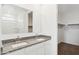 Bright bathroom featuring a granite countertop with double sinks and a view into a walk-in closet at 8516 W Clemente Way, Florence, AZ 85132