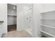 Bright bathroom showcasing a walk-in shower, convenient shelving and a glimpse into the spacious walk-in closet at 8516 W Clemente Way, Florence, AZ 85132